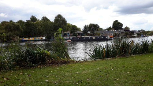 a canal boat goes by along the River Thames